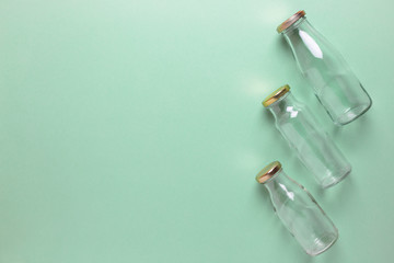Glass bottles for free plastic shopping on a green background. Copy space.