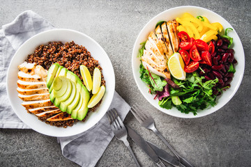 Healthy salad buddha bowl with cherry tomatoes, chicken, beans, sweet pepper and mixed greens and quinoa, avocado, chicken plate top view. Healthy food, dish, dinner