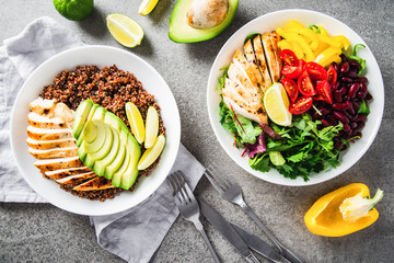 Healthy salad buddha bowl with cherry tomatoes, chicken, beans, sweet pepper and mixed greens and quinoa, avocado, chicken plate top view. Healthy food, dish, dinner