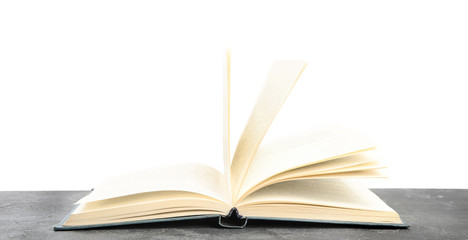 Open book on grey stone table against white background