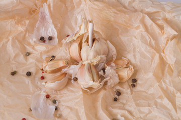 Peeled garlic on parchment. Pimenta dioica and husk around. Food concept.