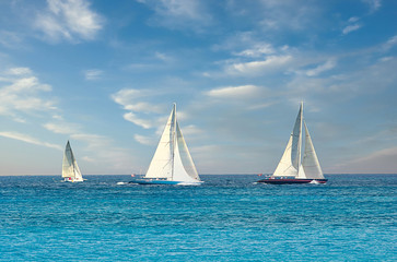 Fototapeta premium Three sailboats on the horizon in the ocean