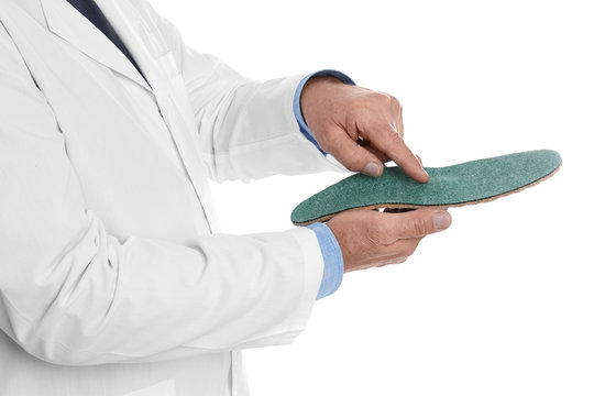 Male orthopedist showing insole on white background, closeup