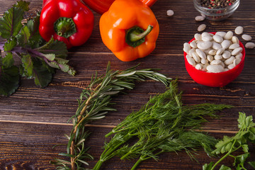 Fresh raw ingredients for healthy cooking. Organic vegetables, legumes and herbs on wooden table. Healthy food concept.