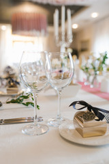 Two empty wine glasses on the holiday table, next to a bonbonniere