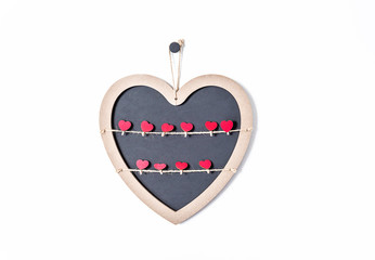 Valentine's day concept. One blackboard shape heart with many red clothespins shape hearts on a white background
