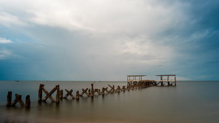 Fototapeta premium Dilapidated old fishing dock collapsing into the sea in Pak Nam Pran Thailand