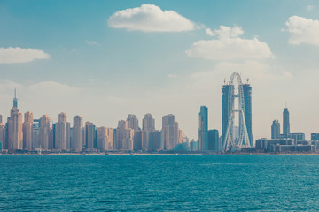 Obraz premium Skyline view of Dubai with palms and skyscraperst. Sunny summer day in Dubai desert. Dubai is the most famous tourist destination in UAE. Ideal place for luxury travel. Creative retro toned image