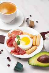 fried eggs with meat and black coffee and coffee capsules with chocolate close-up