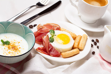 yogurt, fried eggs with meat and bread and coffee close-up