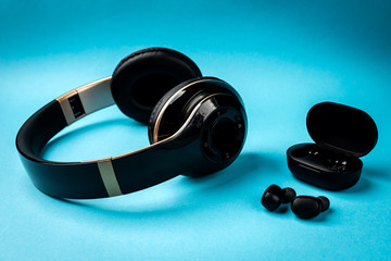 Black wireless headphones on blue background.