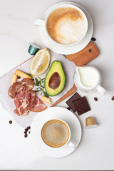 breakfast of avocado, coffee, bacon and lemon on a white background