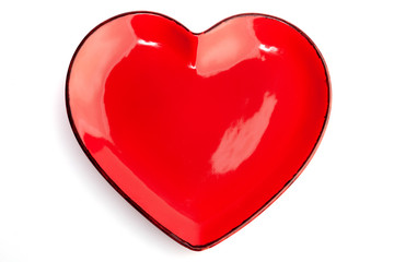 A red heart shape plate isolated on white background. Decoration for Valentine's day, wedding, birthday of any other love celebration.