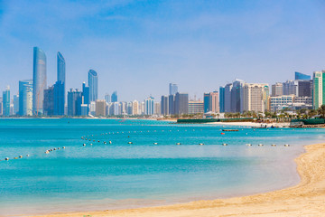 Skyline view of Abu Dhabi panorama with sea, beach and skyscrapers. Sunny summer day in Abu Dhabi -...