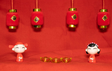 The Chinese New Year decoration on a red background Chinese Couple Figure Model wish for a Luck  and lump of gold and a Chinese Word on Lantern  said Luck