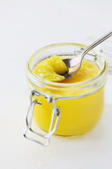 Ghee butter in a jar on a white table.