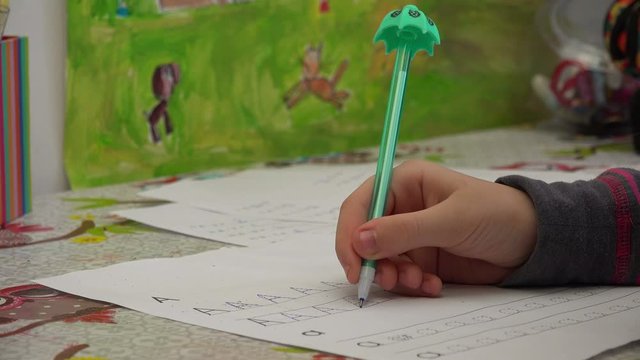 Child doing homework for school at white desk, close up