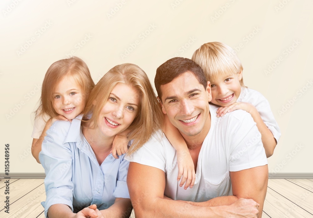 Wall mural Beautiful smiling family on room background