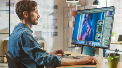 Beautiful Creative Male Video Editor with Beard and Jeans Shirt Works with Footage on His Personal...