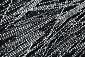 Close up, top down view of macro polypropylene sinusoidal fibers for concrete reinforcement on black stone background