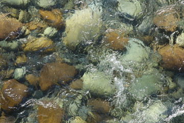 background texture of beautiful stones under clear water of a river