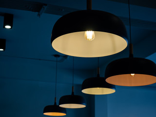 Beautiful round modern ceiling lamps in dark blue room background.