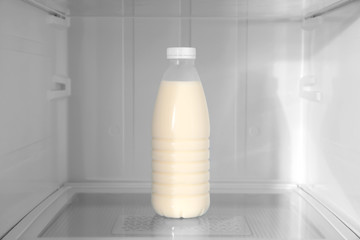 Bottle of milk on shelf inside modern refrigerator