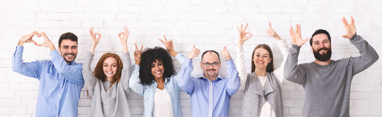 Group of diverse people showing positive signs at studio