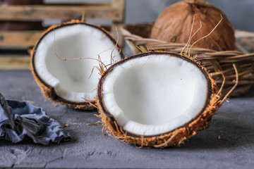 Fototapeta na wymiar Photo of fresh coconut on a table. Tropical palm fruits. Coconut cut in half. Beach fruit. Retro dark background. Rustic wooden board. Front view. Image