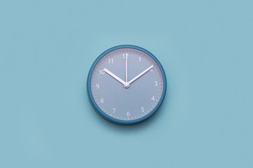 Modern alarm clock on pastel blue background. Minimal concept.