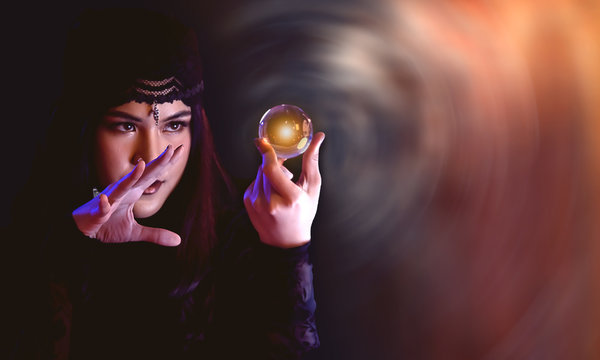 Woman fortune teller is predicting with a crystal ball.