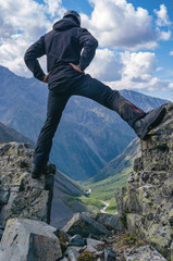 A mountain climber (hiker) on the cliff edge above mountainous valley.