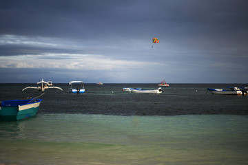 Obraz premium fishing and tourist boats near the shore at sunset on a tropical island