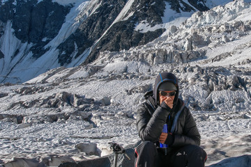 High altitude sickness. Climber breathing oxygen from the O2 tank on the background of glacier and...