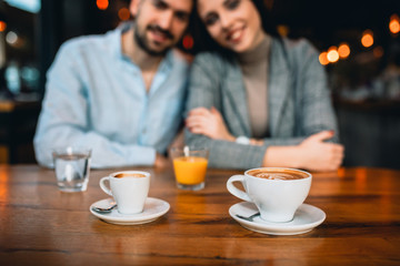 close up of espresso coffee, romantic couple in blurred background