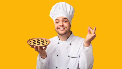 Happy Baker Showing Pie Standing On Yellow Background, Panorama