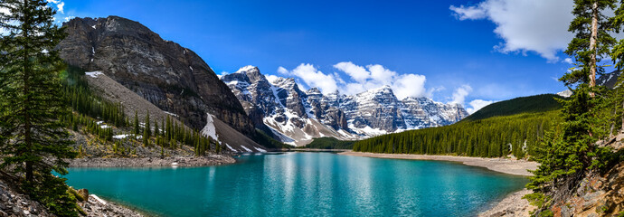 This pristine Moraine Lake overlooks the icy rocky mountains and pine forest. The light breeze...