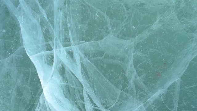 CLOSE UP: Bubbles and cracks create beautiful patterns under the surface of a frozen lake in Jasper National Park. Beautiful turquoise colored water of Lake Abraham freezes in the extreme winter cold.