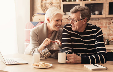 Loving senior couple enjoying morning together at kitchen