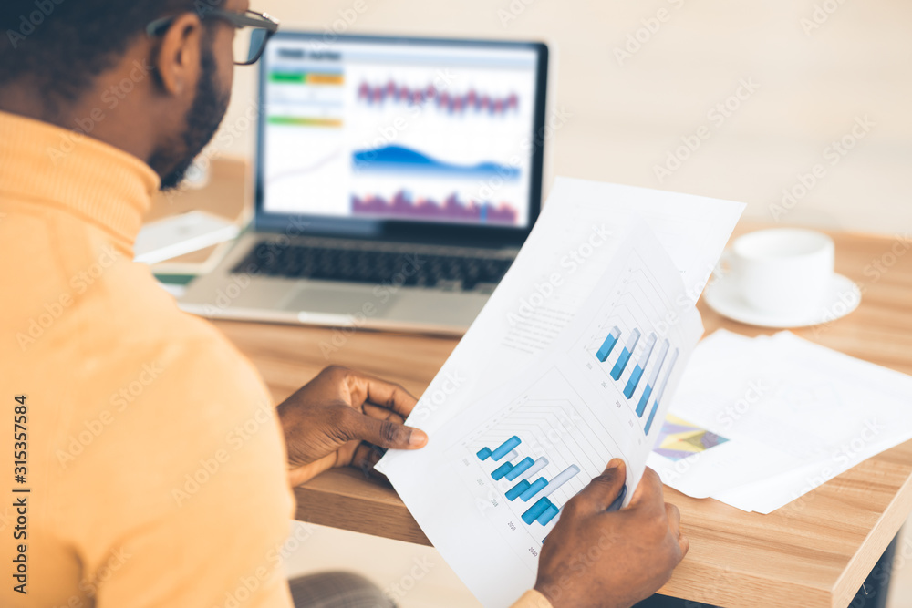 Poster black manager working with diagrams on pc and paper