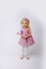 beautiful little blonde girl with a heart shaped Lollipop.valentine's day