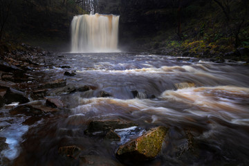 The Afon Hepste river plunging over a band of resistant gritstone to form the waterfall Sgwd yr Eira which translates into 'Fall of snow' and often referred to as the waterfall you can walk under.