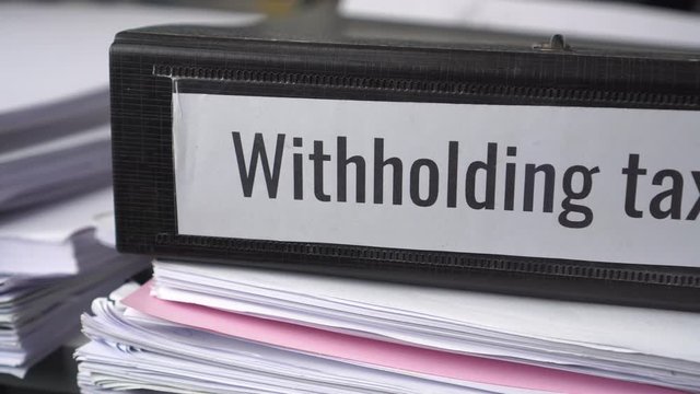 Tax Time,Stack of taxes binders report Document of Withholding tax and corporate tax for accountant.withholding tax sometimes applies to royalties, rent or even sale duty must be paid to government.4K