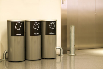 Three types of bins for separating are placed in front of the passenger lift.