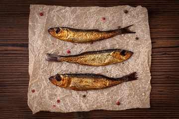 Smoked Baltic herring with spices on wooden board