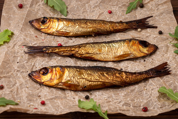 Smoked herring on a brown paper  with pepper and salads