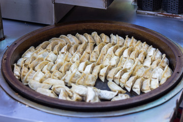 Pork and Cabbage Dumplings (Guotie or Jiaozi). Gyoza. Frying the dumplings from the steam. Cooking the gyoza Japanese style. Asian street food. Regional Food