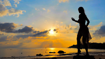 Fototapeta na wymiar Dancing female silhouette against the sky during sunset