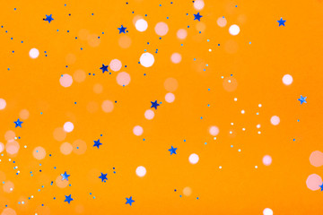 Orange festive background with blue stars and sparkles. The concept of the celebration, the day of St. Valentine, New Year, birthdays, ceremonies, events, etc.