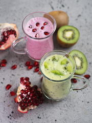 Winter seasonal smoothie drinks detox. Two glasses of green and red smoothies. Kiwi and pomegranate homemade yogurt. Healthy eating concept